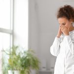 Portrait of stressed female doctor in clinic