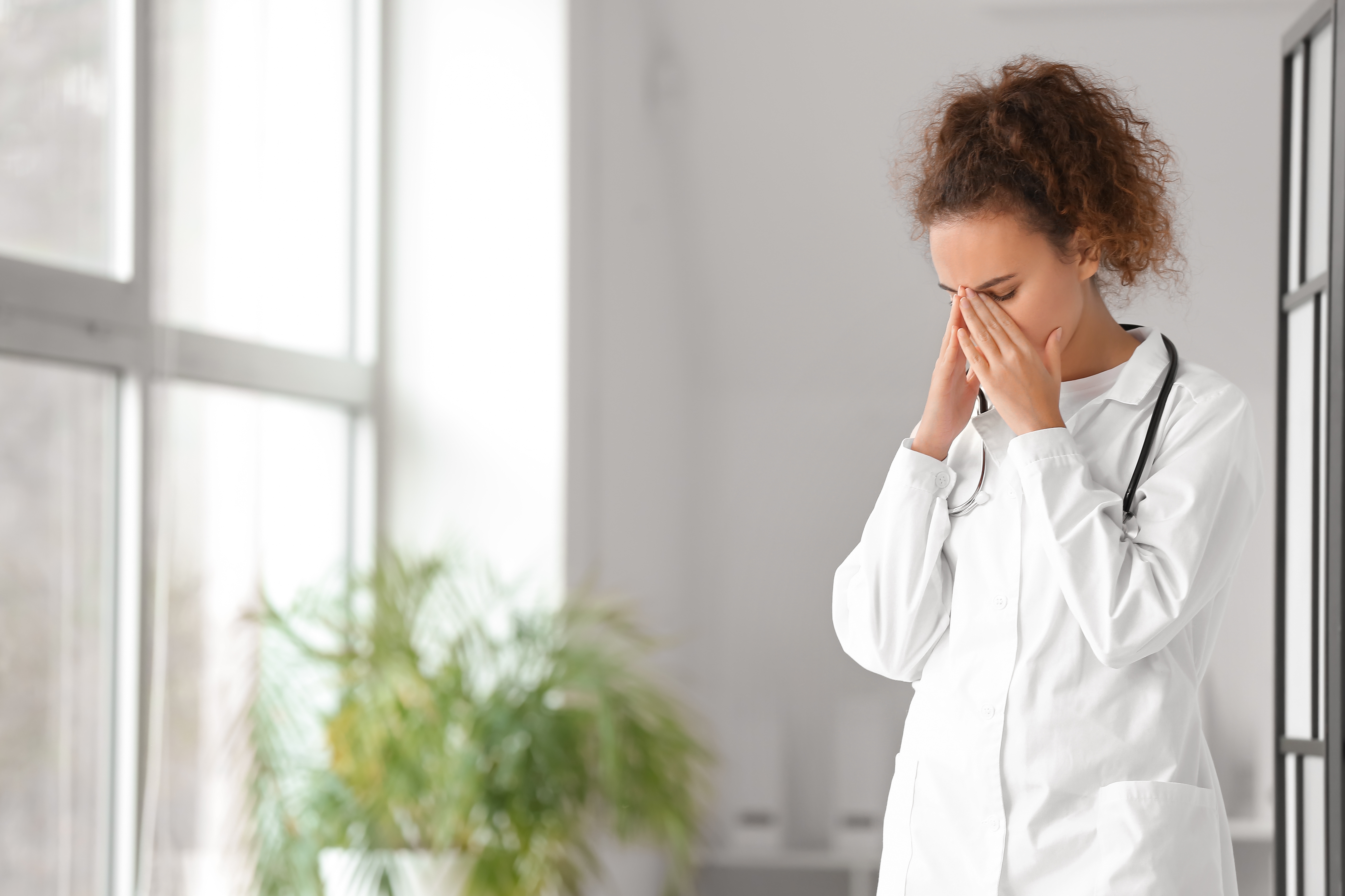 Portrait of stressed female doctor in clinic